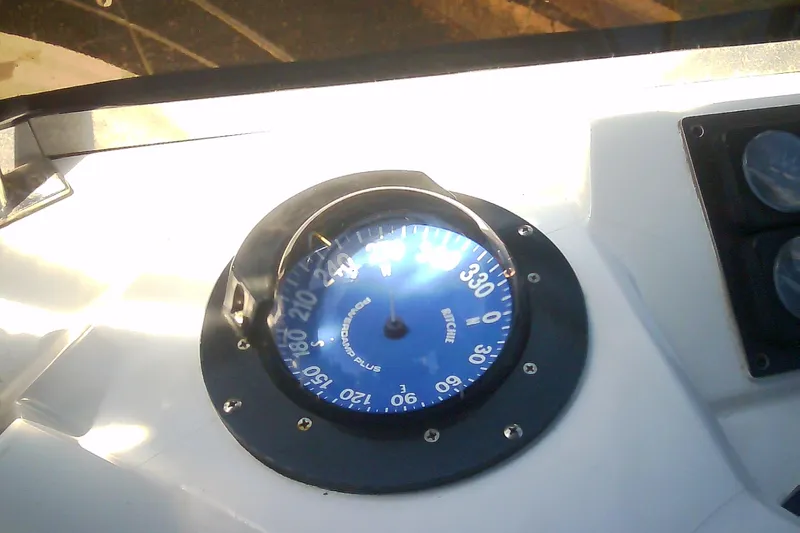 Slide: The Image of Boat compass on a 1999 Sabre 34, displaying navigational directions. - 26