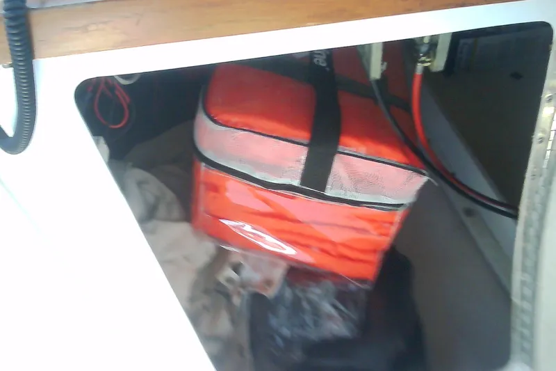 Slide: The Image of Storage compartment in a 1999 Sabre 34 boat with red bag and cables. - 30