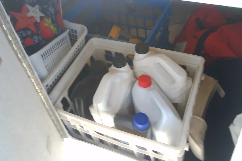 Slide: The Image of Storage compartment with plastic containers and assorted items on a Sabre 34, 1999 model. - 31