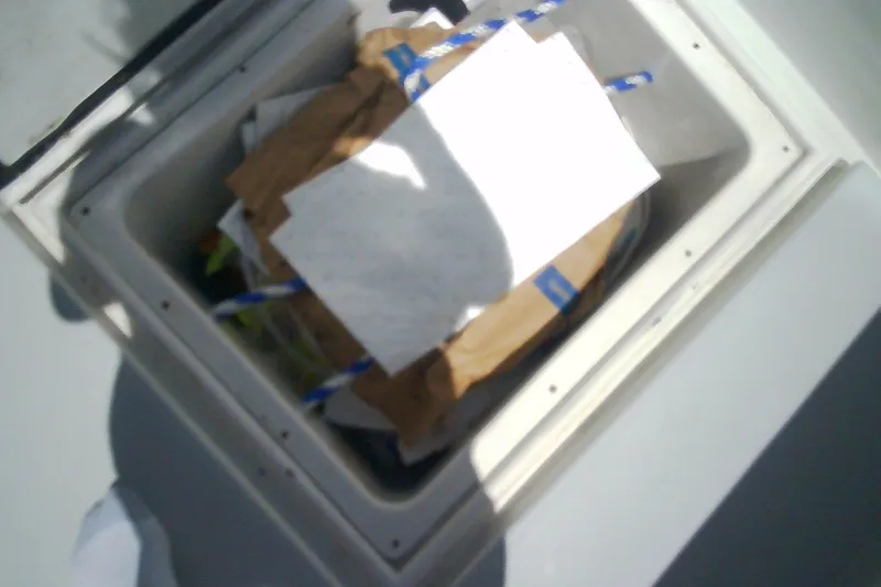 Slide: The Image of Open storage compartment on Sabre 34 boat, filled with various items, 1999 model. - 46