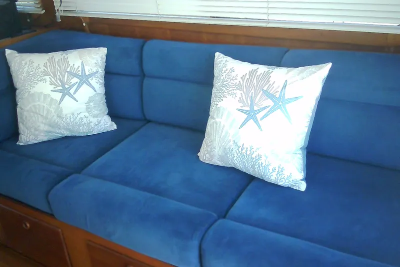 Slide: The Image of Interior of 1999 Sabre 34 yacht with blue sofa and nautical-themed pillows. - 52