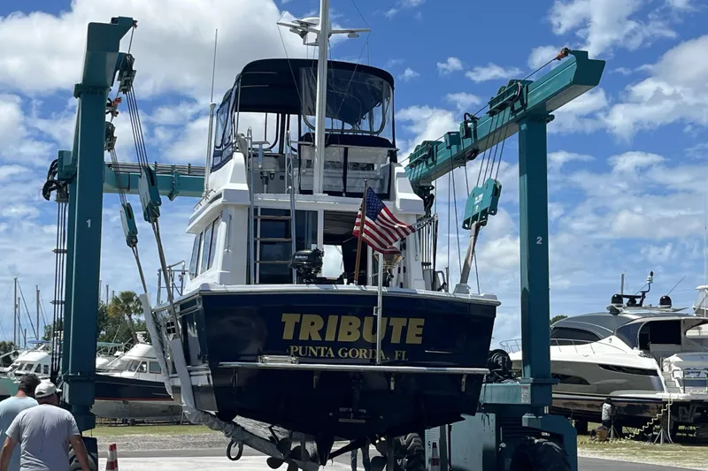 Slide: The Image of 1999 Sabre 34 boat named "Tribute" on water, houses in background. - 90