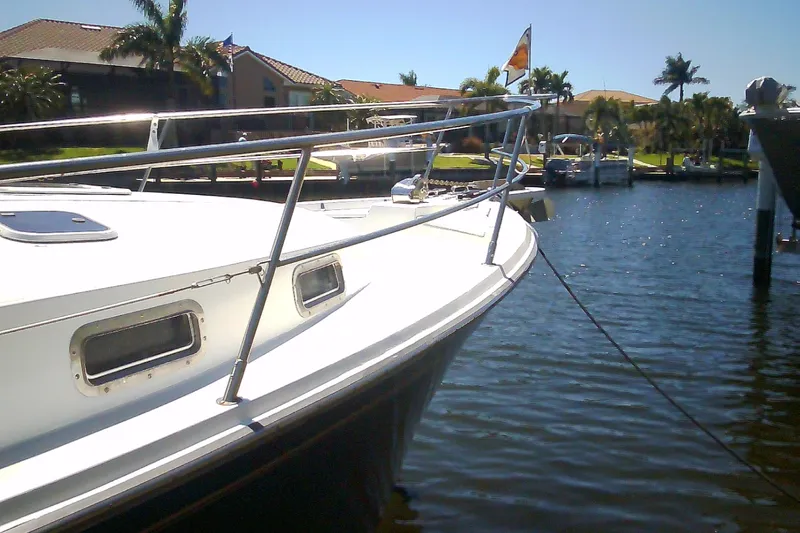 Slide: The Image of 1999 Sabre 34 boat docked in a sunny marina with palm trees. - 3