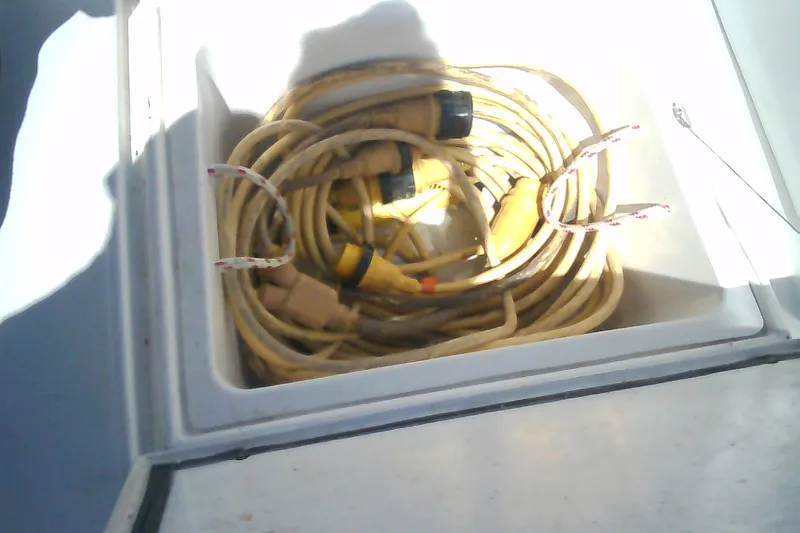Slide: The Image of Coiled yellow power cables in storage compartment of 1999 Sabre 34 boat. - 44
