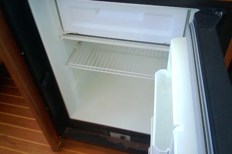 Slide: The Image of Open refrigerator inside a 1999 Sabre 34 boat, showing empty shelves. - 48