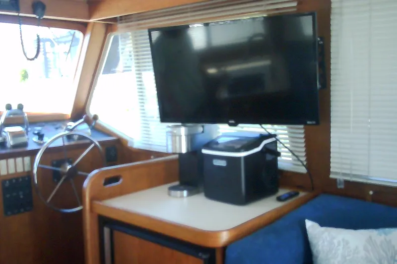 Slide: The Image of Interior of a 1999 Sabre 34 boat with steering wheel and mounted TV. - 50
