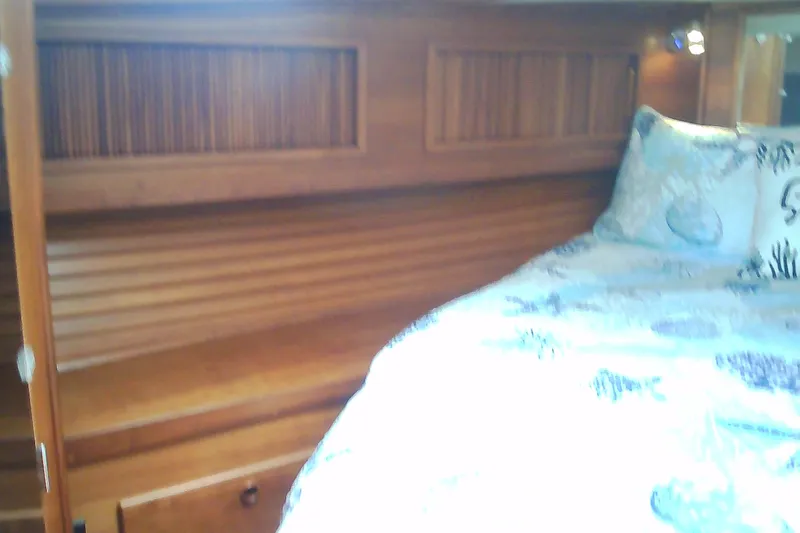 Slide: The Image of Cozy cabin interior of 1999 Sabre 34 yacht with wooden paneling and patterned bedding. - 60