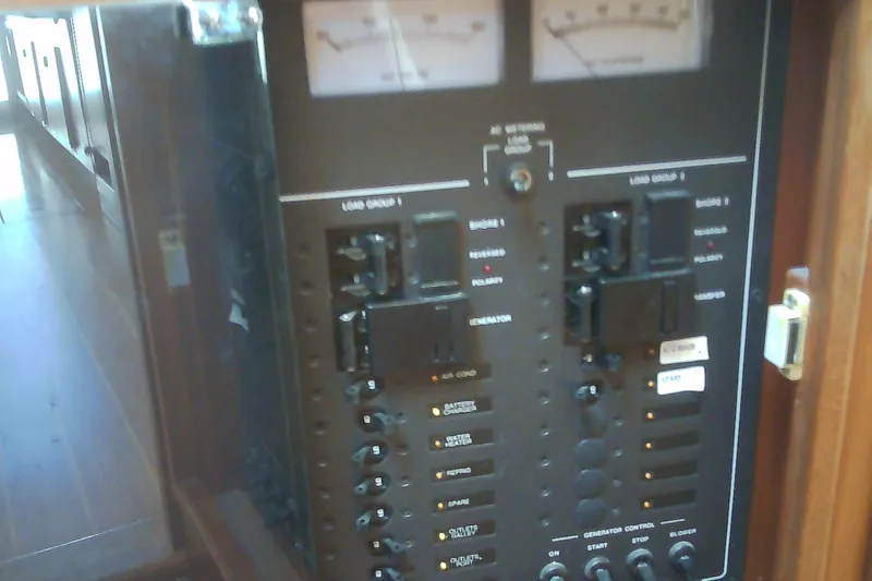 Slide: The Image of Electrical control panel on a 1999 Sabre 34 boat, featuring switches and gauges. - 63