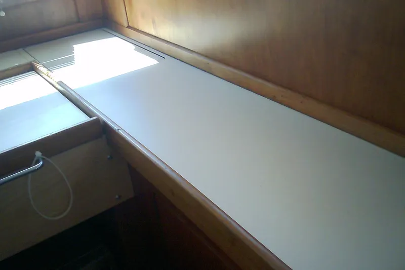 Slide: The Image of Interior view of a 1999 Sabre 34 sailboat, featuring a wooden cabin and countertop. - 73