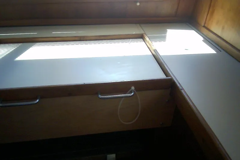 Slide: The Image of Interior view of a 1999 Sabre 34 sailboat, featuring wooden cabinetry and natural light. - 74