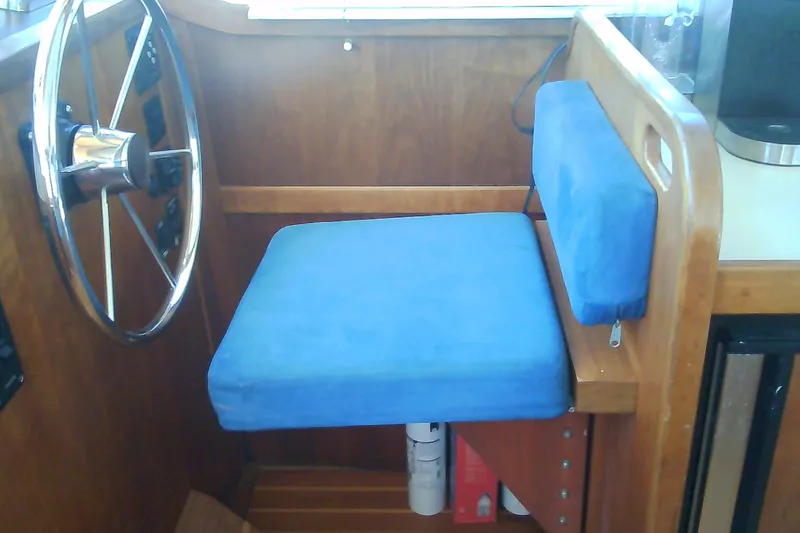 Slide: The Image of Blue cushioned helm seat in 1999 Sabre 34 boat interior. - 77