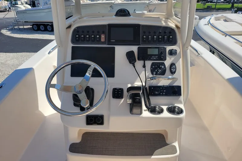 Slide: The Image of 2019 Grady-White 251 Coastal Explorer boat dashboard with steering wheel and controls. - 2