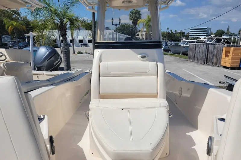 Slide: The Image of 2019 Grady-White 251 Coastal Explorer boat interior with seating, docked under sunny skies. - 6