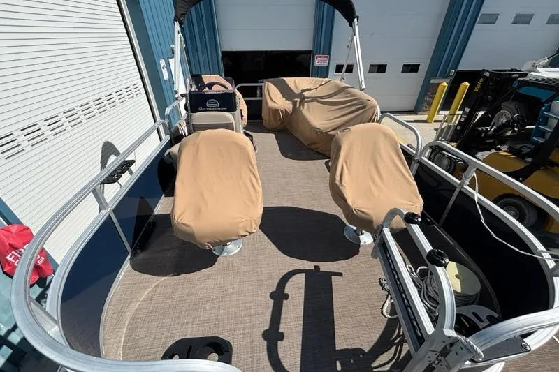 Slide: The Image of 2022 Sun Tracker Bass Buggy 16 XL pontoon boat with covered seats in a marina. - 3
