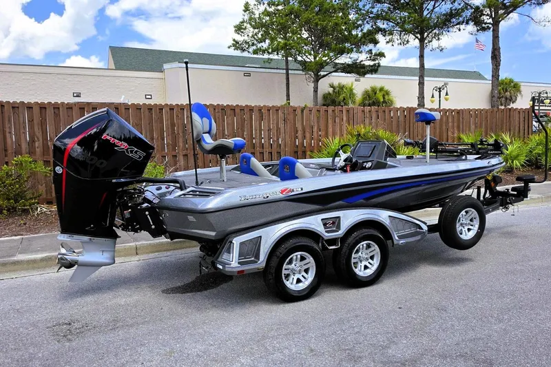 Slide: The Image of 2026 Ranger Z518 Cup-Equipped boat with dual axle trailer, parked outdoors. - 1