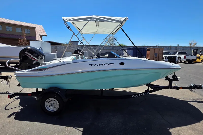The Image of 2026 Tahoe T16 boat with canopy on trailer, parked outdoors under clear sky. - 0