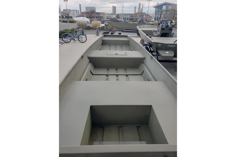 Slide: The Image of 2026 Tracker Grizzly 15 Jon boat displayed outdoors, showcasing spacious interior design. - 2