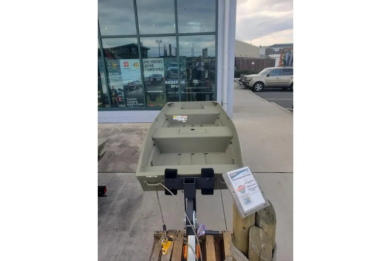 Slide: The Image of 2026 Tracker Grizzly 15 Jon boat displayed outside a showroom. - 3