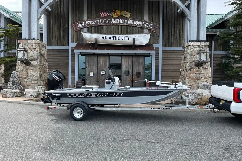 Slide: The Image of 2026 Tracker Bass Tracker Classic CC boat on trailer outside outdoor store. - 2