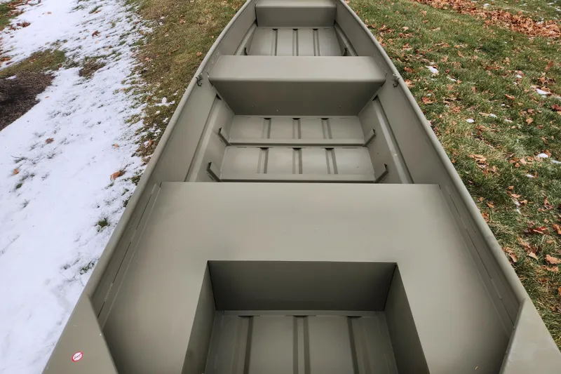 Slide: The Image of 2026 Tracker Grizzly 14 Jon boat on grass and snow background. - 2