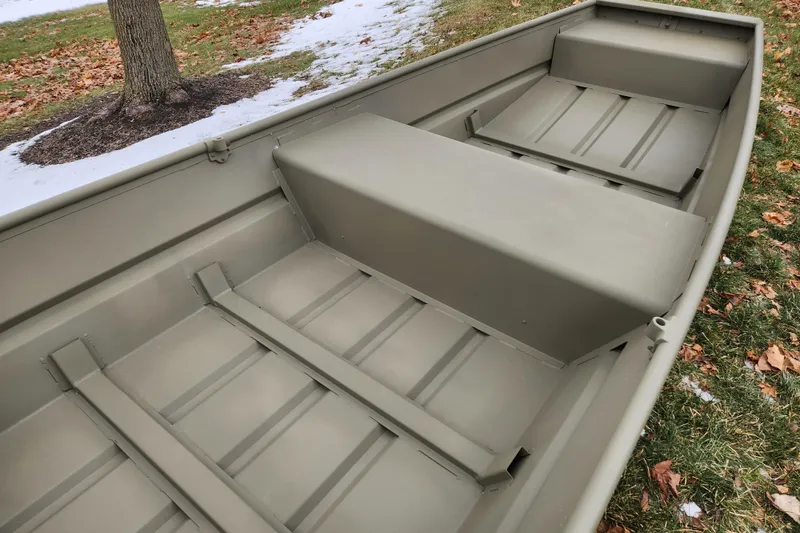 Slide: The Image of 2026 Tracker Grizzly 14 Jon boat interior on grassy, snowy ground. - 3