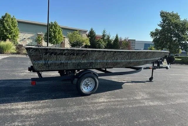 Slide: The Image of 2026 Tracker Grizzly 1648 Utility boat on trailer, parked outdoors on sunny day. - 23