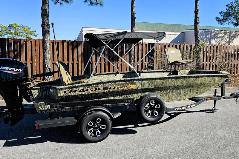 The Image of 2026 Tracker Grizzly 1756 T Marsh boat on trailer, camo design, with Mercury outboard motor. - 0