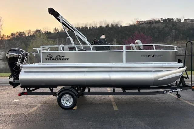 The Image of 2026 Sun Tracker Bass Buggy 18 DLX pontoon boat on trailer, parked outdoors. - 0