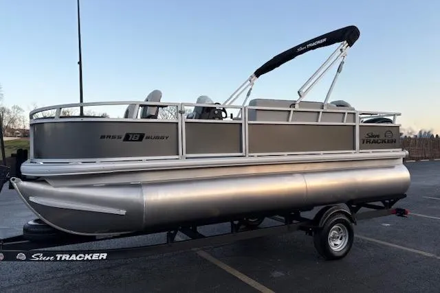 Slide: The Image of 2026 Sun Tracker Bass Buggy 18 DLX pontoon boat on trailer in parking lot. - 10