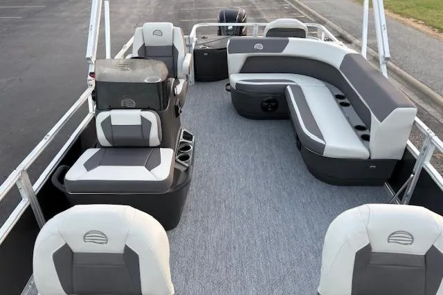 Slide: The Image of 2026 Sun Tracker Bass Buggy 18 DLX pontoon boat interior with gray seating and carpet. - 13