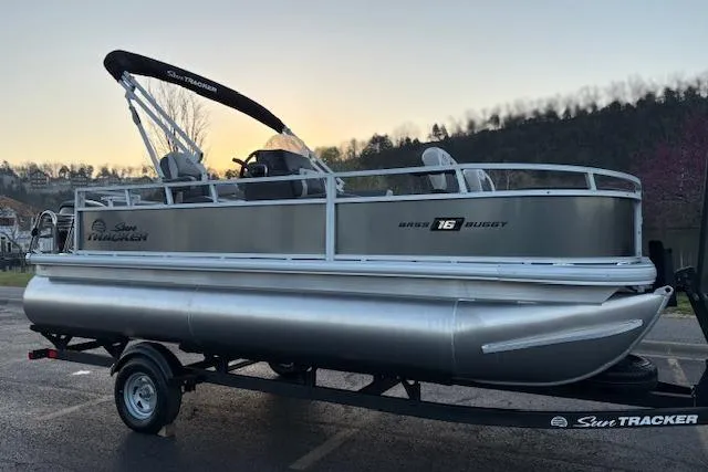 Slide: The Image of 2026 Sun Tracker Bass Buggy 18 DLX pontoon boat on trailer at sunset. - 4