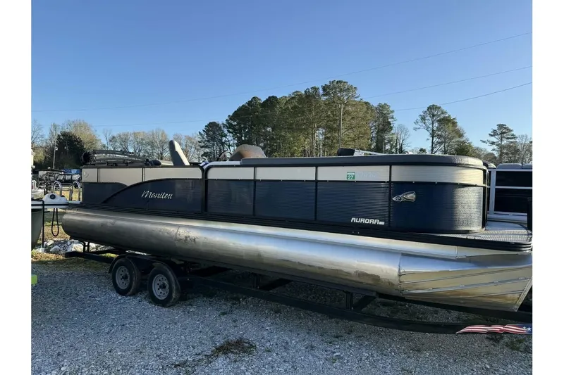 The Image of 2022 Manitou 25 Aurora pontoon boat on trailer, parked outdoors. - 1