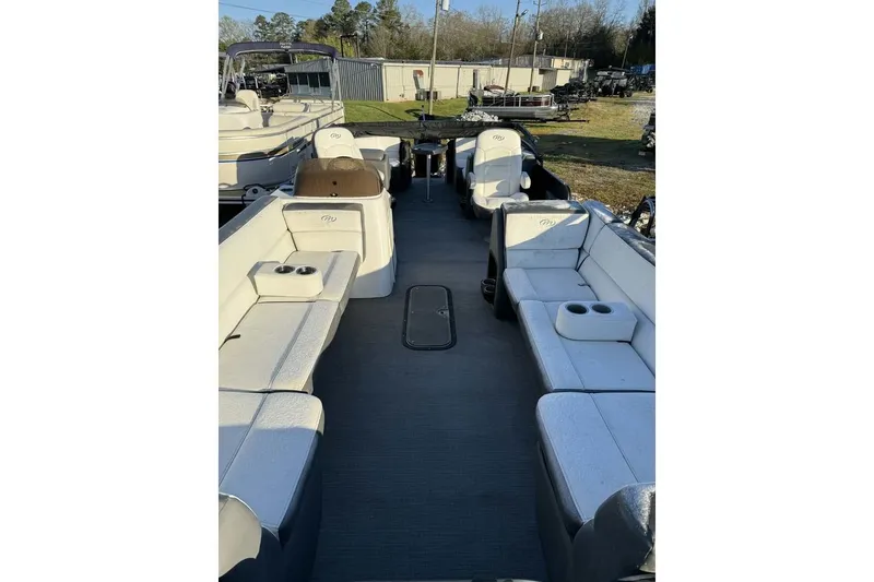 Slide: The Image of 2022 Manitou 25 Aurora pontoon boat interior with spacious seating and cup holders. - 13