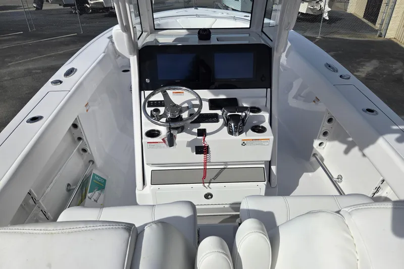 Slide: The Image of 2026 Sportsman Heritage 261 Center Console boat interior with steering wheel and controls. - 13