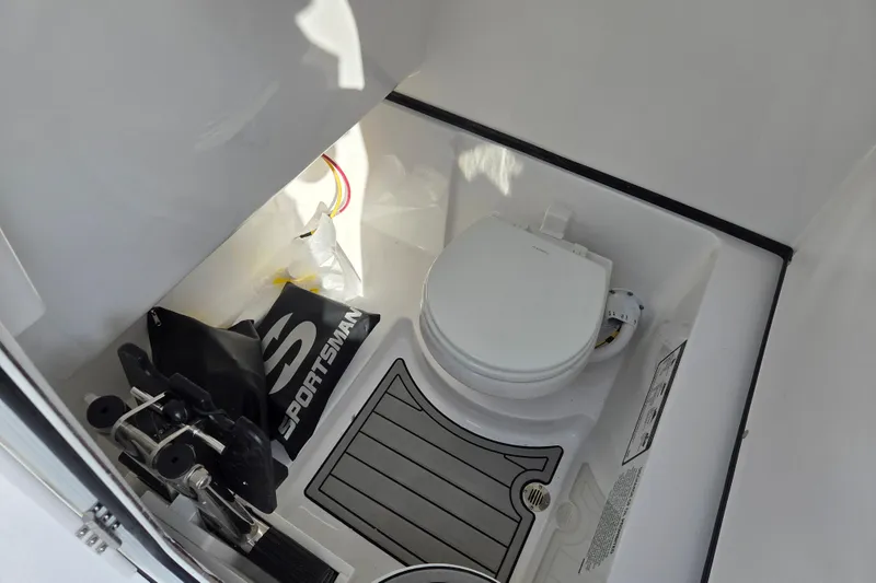 Slide: The Image of Interior of 2026 Sportsman Heritage 261 Center Console boat with toilet and storage area. - 17