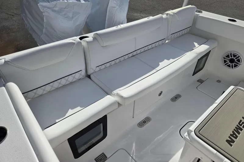 Slide: The Image of 2026 Sportsman Heritage 261 Center Console boat interior with cushioned seating and speaker. - 18