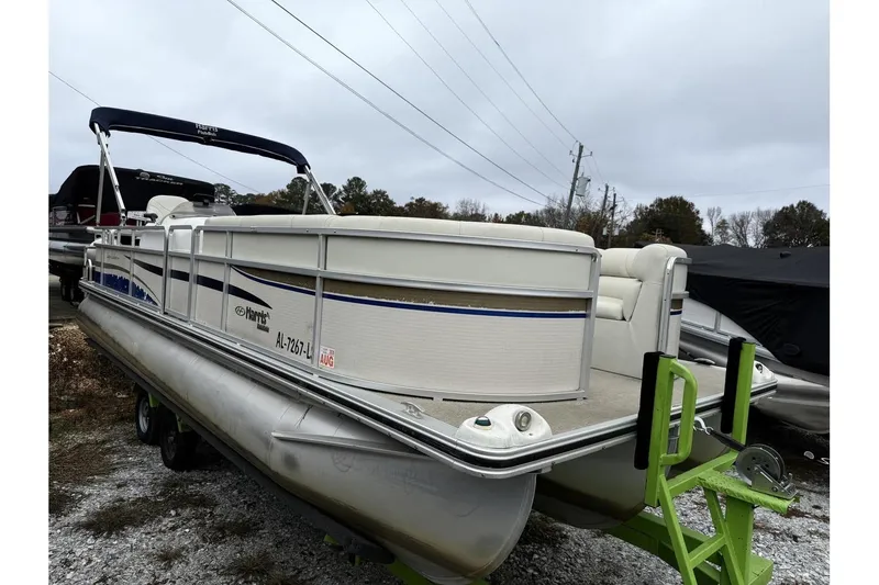 The Image of 2007 Harris Classic 240 I/O pontoon boat on trailer, parked outdoors. - 1
