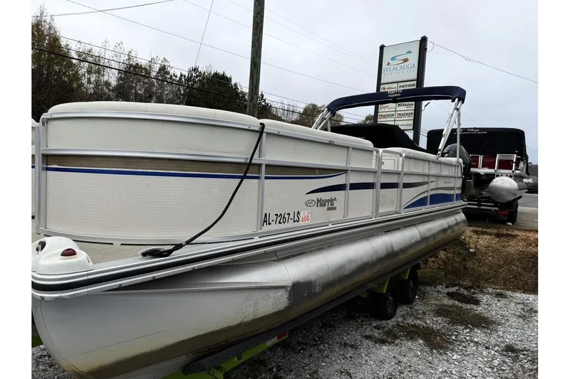 Slide: The Image of 2007 Harris Classic 240 I/O pontoon boat parked outdoors. - 2