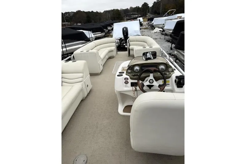 Slide: The Image of 2007 Harris Classic 240 I/O pontoon boat interior with white seating and steering console. - 7