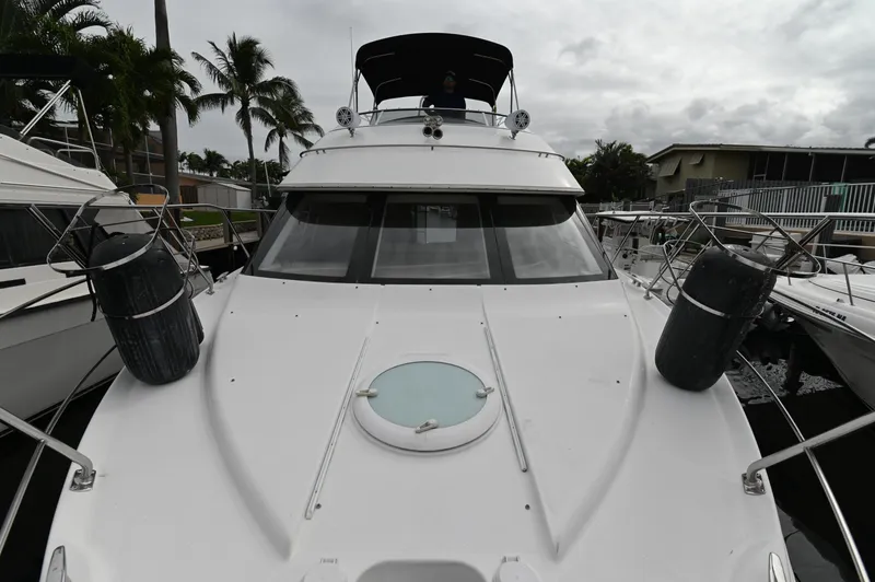 Slide: The Image of 2005 Carver 36 Super Sport yacht docked at marina with palm trees in background. - 2