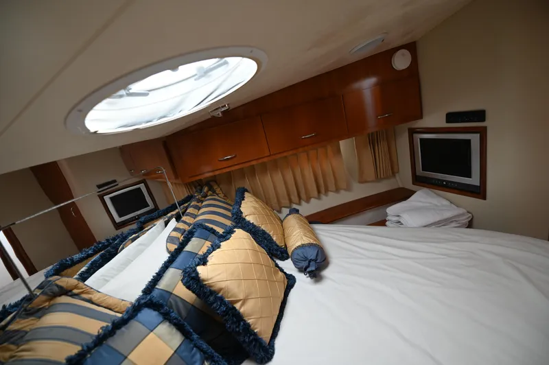 Slide: The Image of Luxurious bedroom interior of 2005 Carver 36 Super Sport yacht with elegant bedding and porthole. - 37