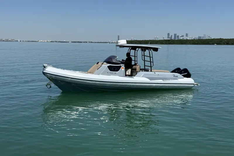 Slide: The Image of 2026 Ranieri Cayman Executive boat on calm water with city skyline in background. - 1