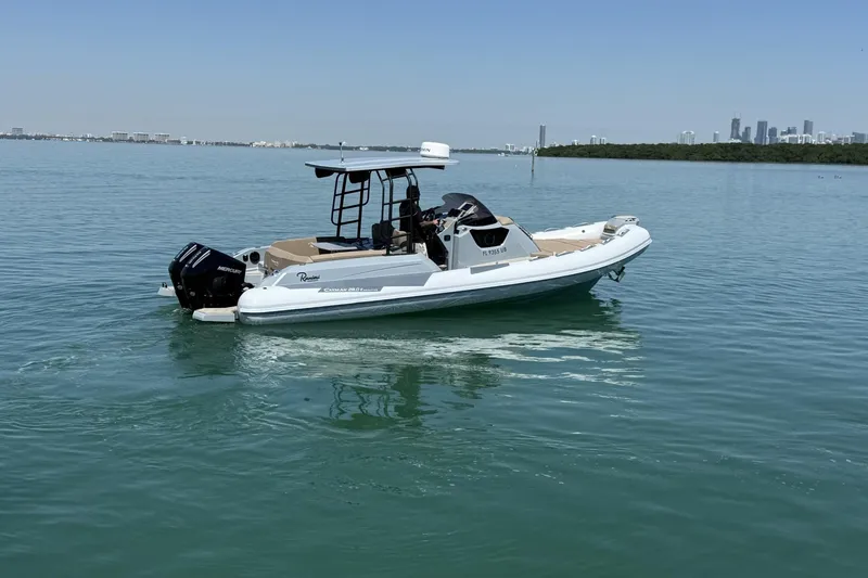 Slide: The Image of 2026 Ranieri Cayman Executive boat on calm water with city skyline in background. - 10