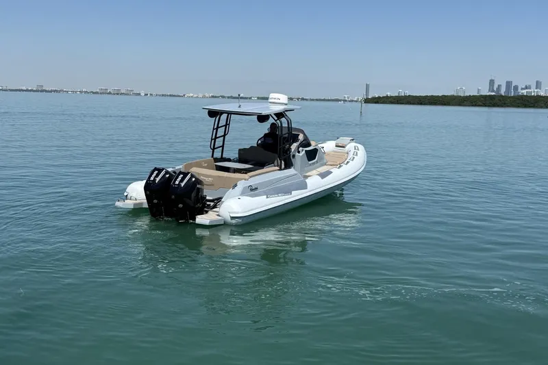 Slide: The Image of 2026 Ranieri Cayman Executive boat on calm water with city skyline in background. - 11