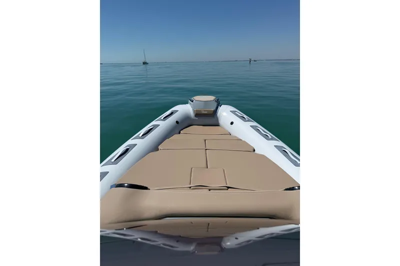 Slide: The Image of 2026 Ranieri Cayman Executive boat on calm water, featuring a spacious sun deck. - 14