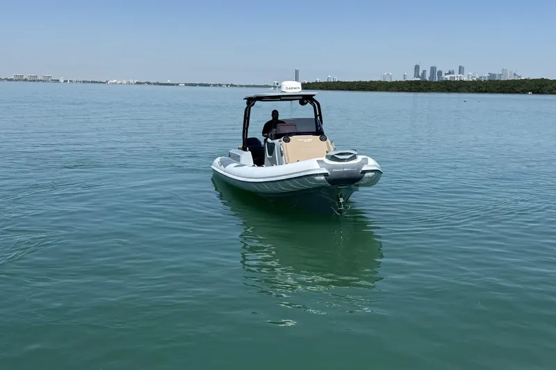 Slide: The Image of 2026 Ranieri Cayman Executive boat on calm water with city skyline backdrop. - 5