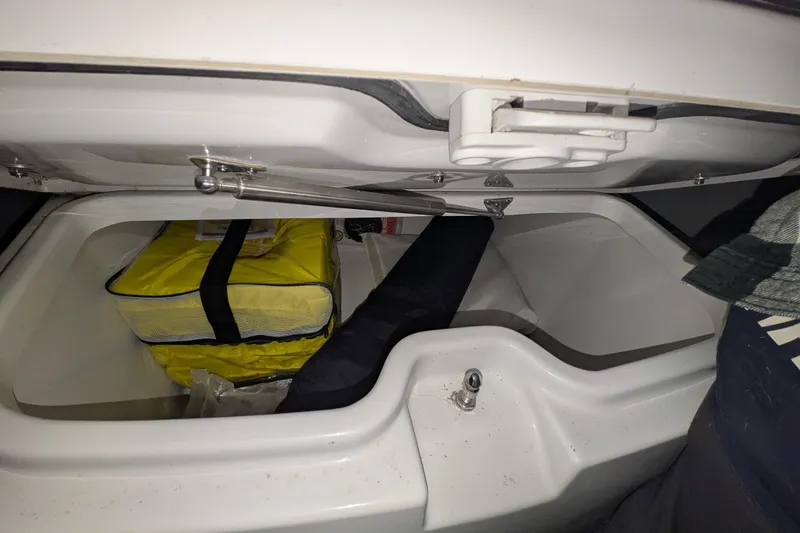Slide: The Image of Storage compartment of 2022 Sportsman Open 322 Center Console with yellow bag inside. - 12