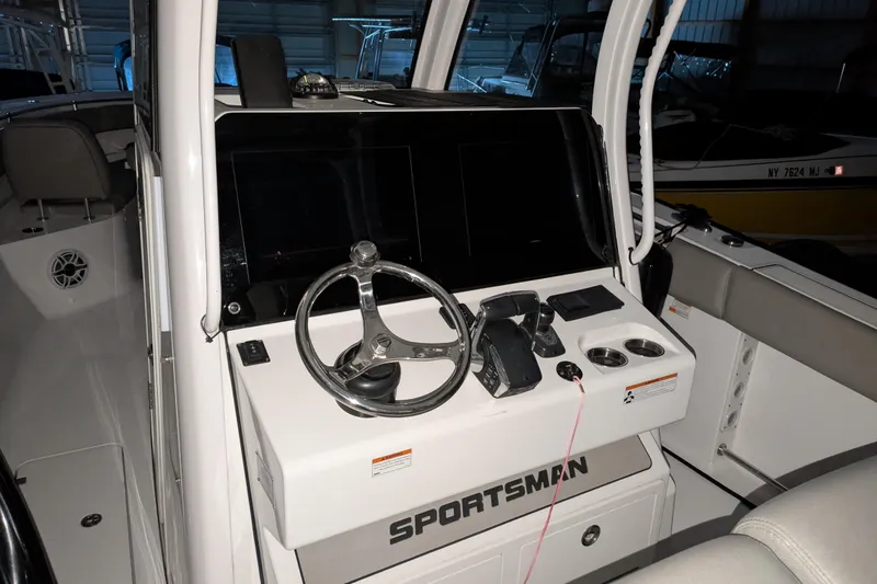 Slide: The Image of 2022 Sportsman Open 322 Center Console boat dashboard with steering wheel and controls. - 19