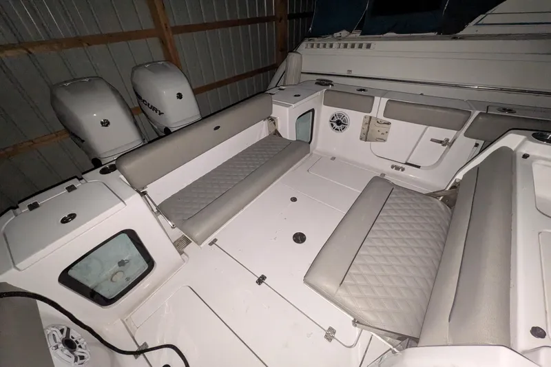 Slide: The Image of 2022 Sportsman Open 322 Center Console boat interior with cushioned seating and dual Mercury engines. - 20