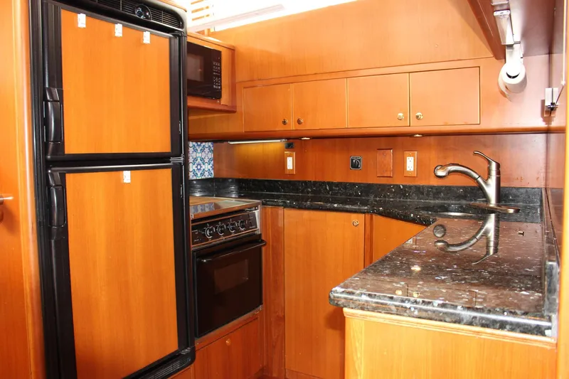 Slide: The Image of Luxurious kitchen interior of 2007 Jefferson 45 Motor Yacht with wood cabinetry and granite countertops. - 14